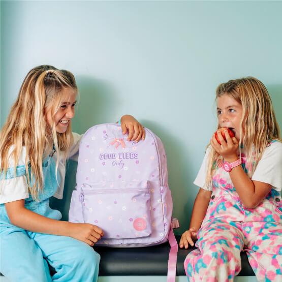 Meninas sentadas com mochila escolar 